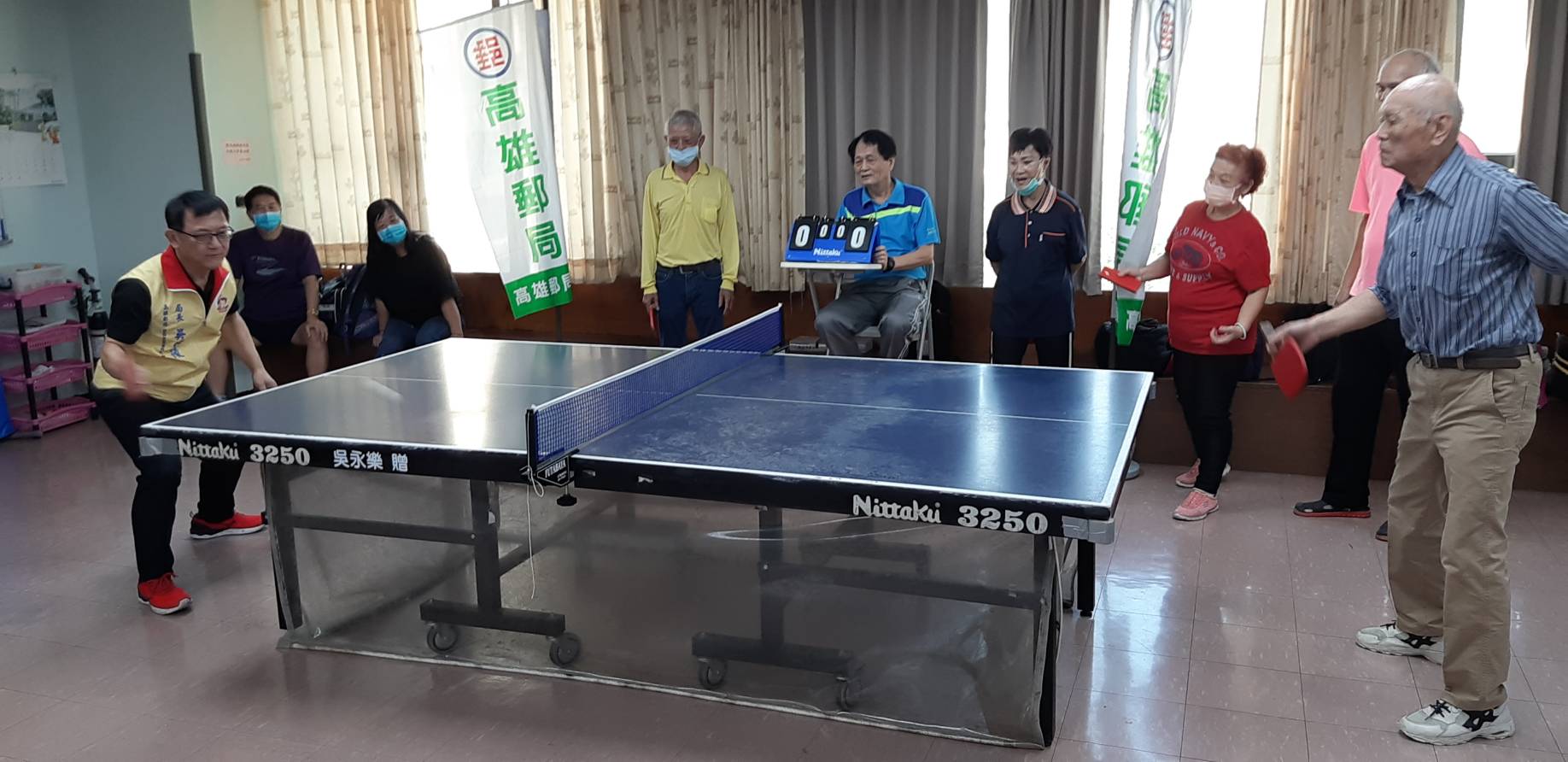 高雄郵局吳信陵局長與93歲人瑞進行桌球互動